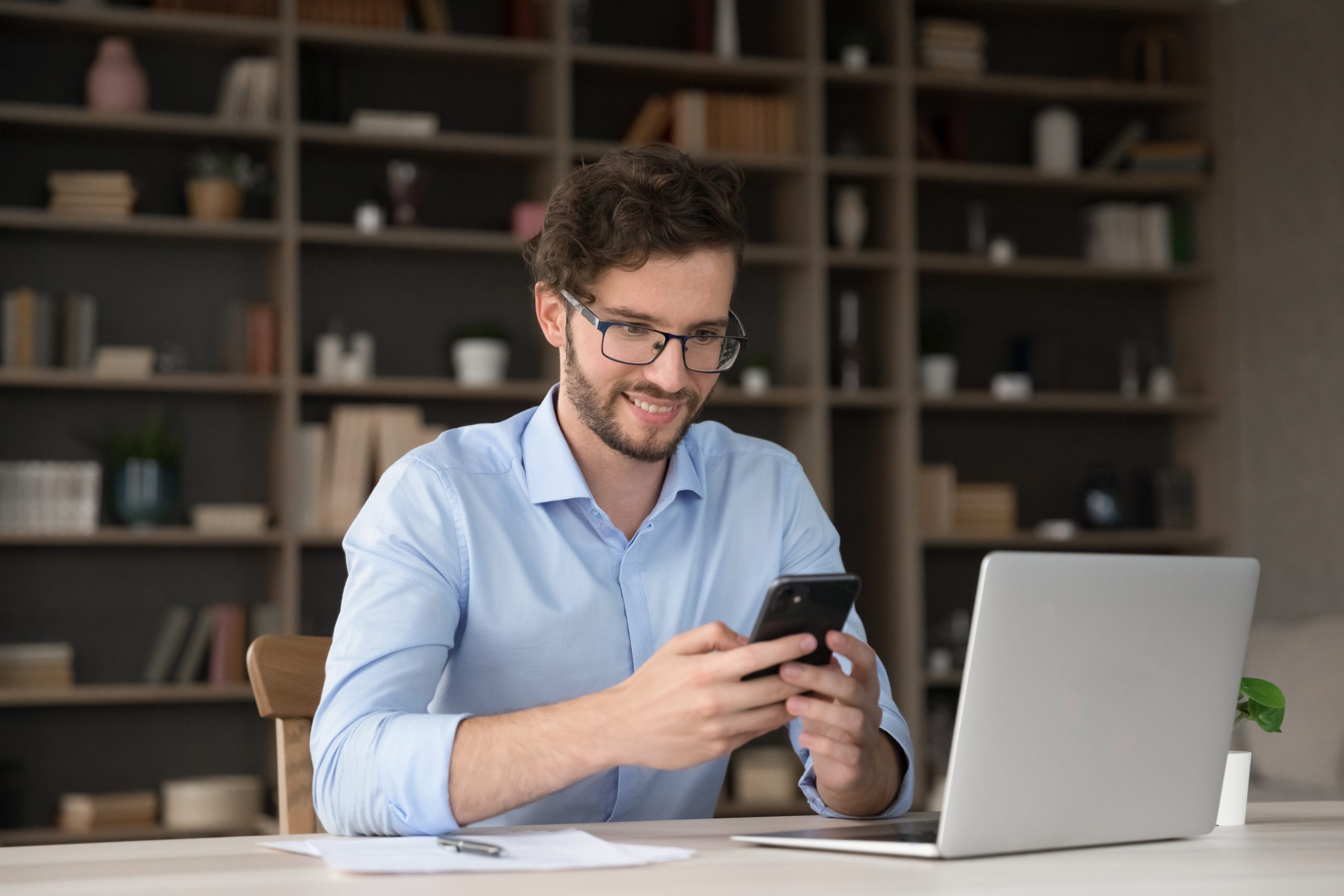 Easy and productive multitasking. Smiling young man Making Property Transactions Easier for Everyone Involved